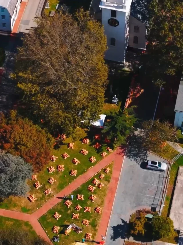 Aerial view of a grassy area with a pathway and many chairs set up.
